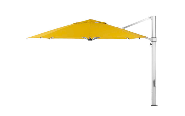 The Ultra Cantilever Umbrella - 13 Octagon by Ledge Lounger is a large yellow patio umbrella with a tilting mechanism, supported by a sturdy silver pole. Pair it with a rechargeable outdoor umbrella light to illuminate your evening gatherings perfectly.