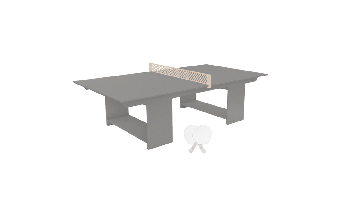 The Ledge Lounger Table Tennis Set features a modern gray table with a mesh net on a rectangular base, perfect for outdoor fun. It includes two white paddles and a small ball, completing the minimalist design.