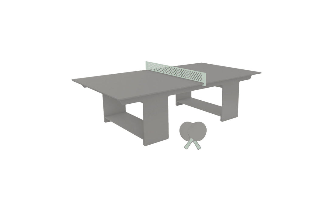 The Ledge Lounger Table Tennis Set features a minimalist gray table with a light green net and two gray paddles leaning against one of its legs, making it perfect for any outdoor entertainment setup.
