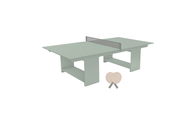 The Ledge Lounger Table Tennis Set features a minimalist design with a metal net, two lightweight wooden paddles, and a ball on a green table, perfect for modern outdoor entertainment.