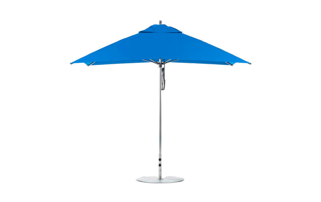 A blue Ledge Lounger Essential Fiberglass Umbrella with a silver pole and round base is open against a white background. The 8.5 rectangle pulley design features marine-grade fabrics and wind resistance for outdoor durability.