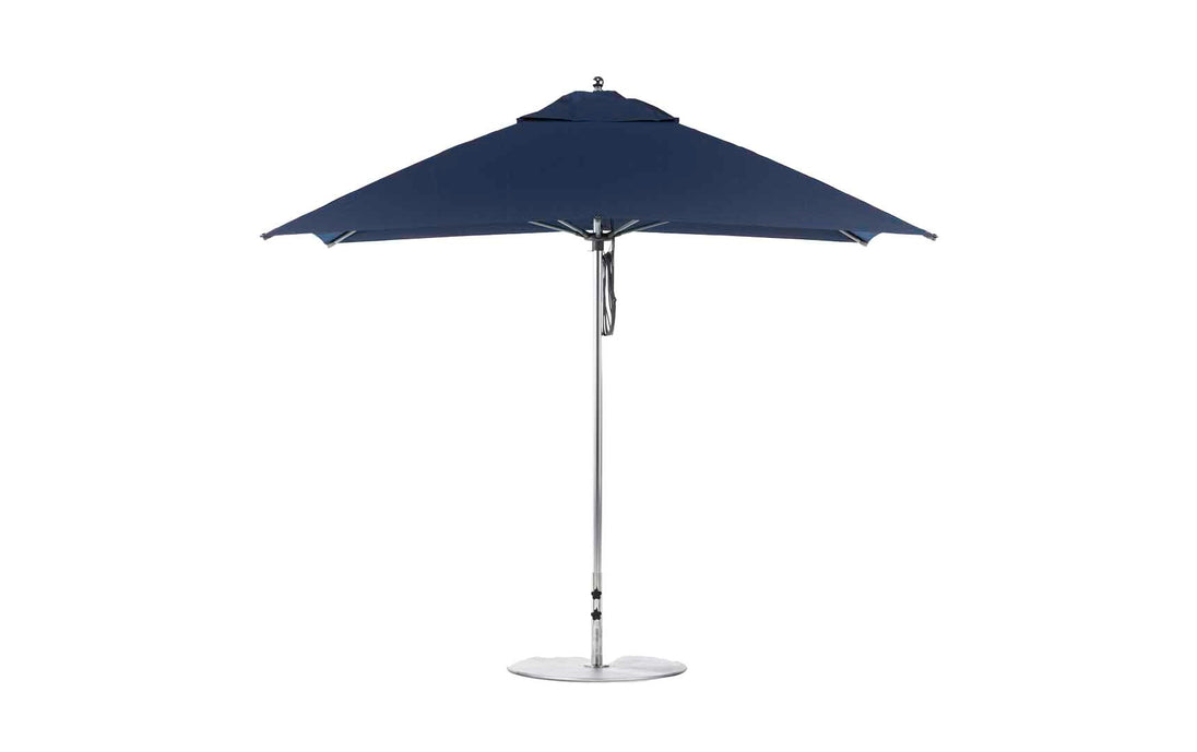 The Ledge Lounger Essential Fiberglass Umbrella, with a sleek design, features a blue 8.5 rectangle canopy and silver pole with a round base. Made from marine-grade fabrics, this wind-resistant umbrella provides perfect shade for any garden or patio setting.