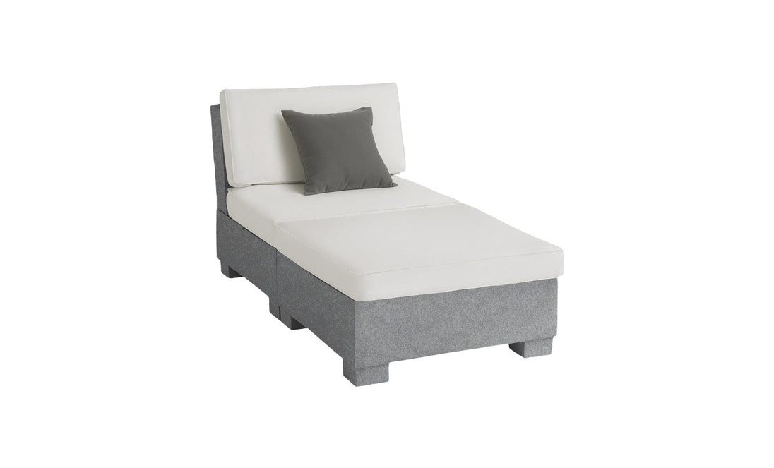 The Ledge Lounger Signature Sectional 2 Piece Sun Chair is a modern gray and white chaise lounge, featuring a dark gray accent pillow. It offers superior relaxation with its cushioned backrest and seat crafted from durable materials, supported by a sturdy base on a plain white background.