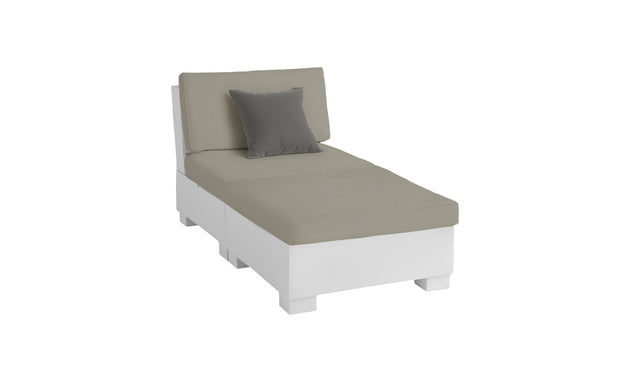The Ledge Lounger Signature Sectional 2 Piece Sun Chair is a modern white lounge chair made from durable materials, featuring a light grey cushion and darker grey throw pillow. Its minimalist design and low backrest offer refined relaxation against any plain white backdrop.