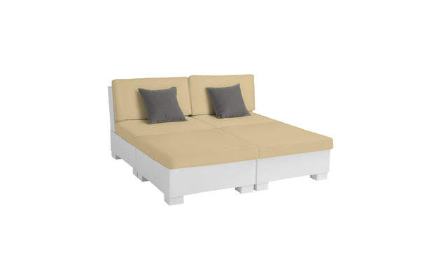 The Signature Sectional 4 Piece Sun Chair by Ledge Lounger is a beige modular sofa bed featuring two gray throw pillows, designed for relaxation with its minimalist aesthetic. Set on a white platform, it offers spacious seating, ideal for lounging or sleeping in its flat position against a serene white background.