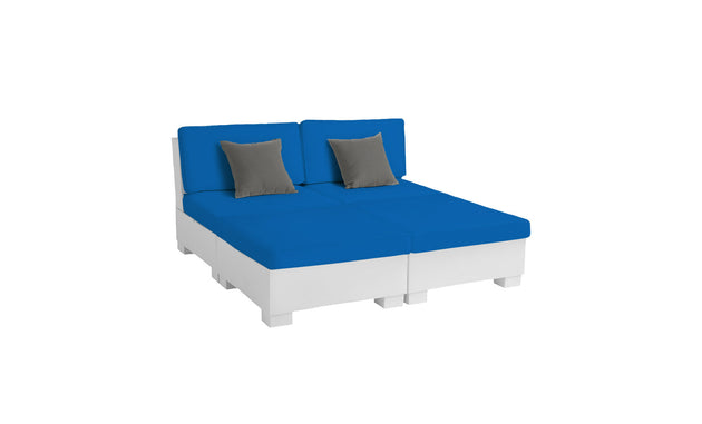 The Signature Sectional 4 Piece Sun Chair by Ledge Lounger features a modular design with a white base, bright blue cushions, and two gray square pillows. Ideal for patio or garden relaxation, the contemporary sofa is showcased against a plain white background.