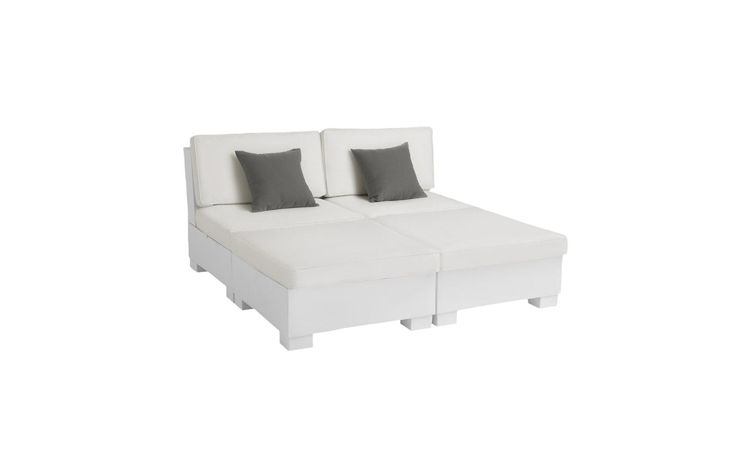 The Signature Sectional 4 Piece Sun Chair by Ledge Lounger is a modern white sectional sofa with spacious seating, featuring two armless sections and backrest cushions. Two gray throw pillows enhance relaxation, and its minimalist design complements contemporary style.