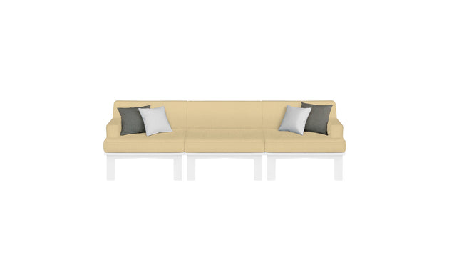 The Mainstay Sectional 3 Piece Sofa by Ledge Lounger is a modern beige three-seater with white metal legs. It includes four throw pillows—two dark gray and two white—symmetrically arranged, completing an elegant look against a plain white backdrop.