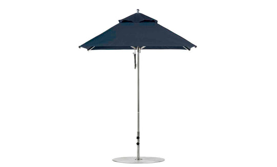 The Premier Aluminum Umbrella - 6.5 Square Pulley by Ledge Lounger is a sleek, dark blue design featuring a wind-resistant metal stand and circular base. Displayed against a white background, its wide canopy is crafted from marine-grade fabrics with a simple, modern aesthetic.