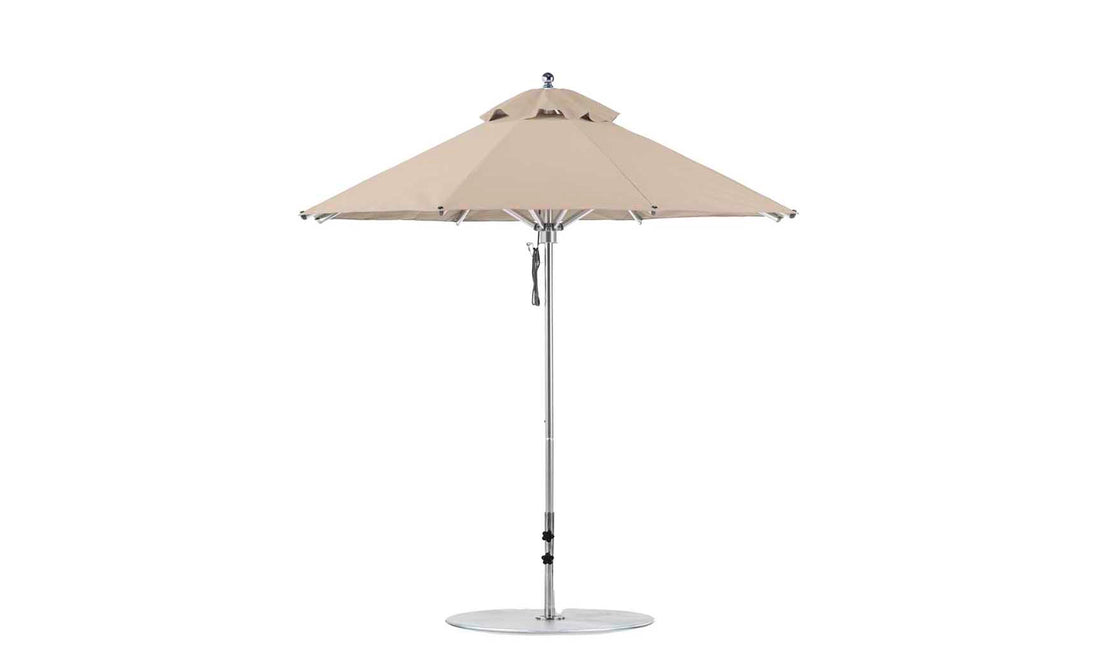 Discover the Ledge Lounger Premier Aluminum Umbrella - 7.5 Octagon Pulley, with a beige canopy and metal pole. It features marine-grade fabrics, a round base, and a vented top for air circulation, creating a wind-resistant design perfect for enhancing your outdoor oasis.