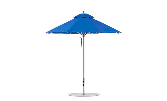 A vibrant blue Ledge Lounger Premier Aluminum Umbrella, boasting a round 7.5 octagon canopy and sleek silver pole on a flat base, is fully open, highlighting its wind-resistant design and marine-grade fabrics for durability and style.