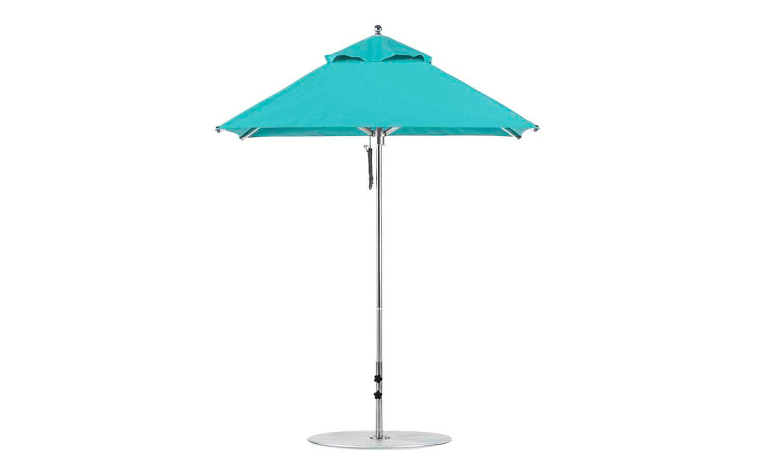 The Ledge Lounger Premier Aluminum Umbrella, featuring a sleek aluminum pole and round silver base, is crafted with marine-grade fabrics for a wind-resistant, durable design. This 6.5 square pulley umbrella has an open flat top, perfect for outdoor use.