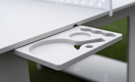 A close-up shows the Ledge Lounger Table Tennis Set holder attached to a table, featuring slots for two paddles and several balls. The grassy, blurred background enhances its outdoor entertainment appeal.