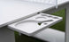 A close-up shows the Ledge Lounger Table Tennis Set holder attached to a table, featuring slots for two paddles and several balls. The grassy, blurred background enhances its outdoor entertainment appeal.