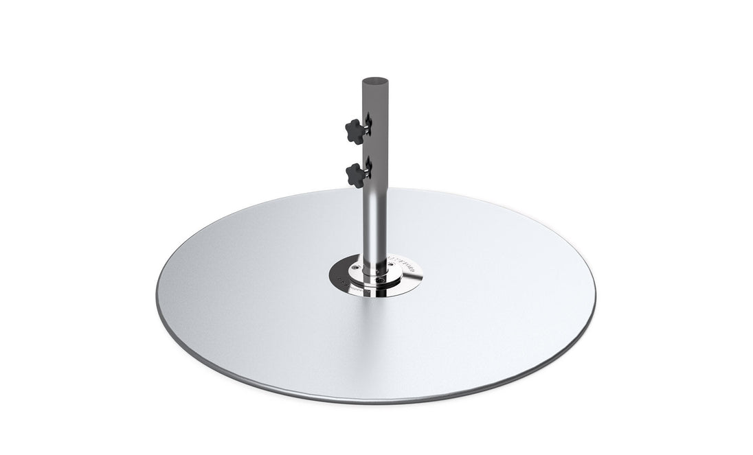 A chrome-finished, disc-shaped object with a central cylindrical pole featuring two knobs resembles the Ledge Lounger Galvanized Steel Stack Umbrella Base. Its sleek, reflective circular design hints at a role in modern outdoor furniture and compatibility with center pole umbrellas.