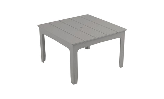 The Mainstay Square Dining Table by Ledge Lounger is light gray with a slatted top and built-in umbrella sleeve. Featuring four straight legs, it presents a simple, modern design ideal for outdoor dining.