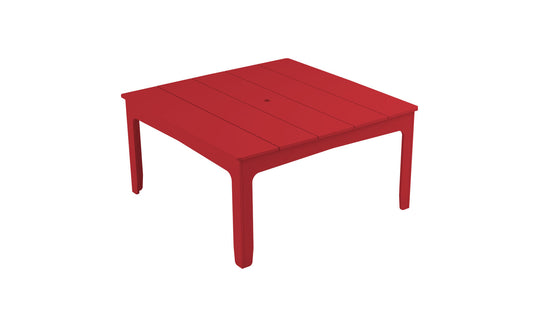 The Mainstay Square Dining Table by Ledge Lounger is a red, square table with a slatted top and four straight legs. It features a built-in umbrella sleeve, set against a plain white background, making it perfect for outdoor dining.