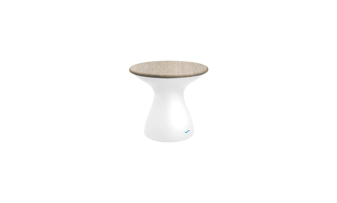 The Autograph Standard Side Table by Ledge Lounger features a smooth, white hourglass-shaped base and a flat, light wood top. This modern minimalist stool doubles as an outdoor side table, perfect for contemporary flair and poolside storage needs.