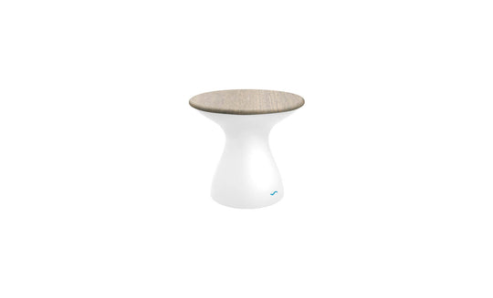 The Autograph Standard Side Table by Ledge Lounger features a smooth, white hourglass-shaped base and a flat, light wood top. This modern minimalist stool doubles as an outdoor side table, perfect for contemporary flair and poolside storage needs.