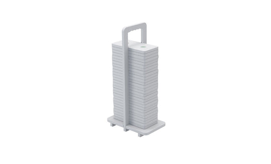 The Dominoes from Ledge Lounger are stacked white square plates with rounded edges, arranged vertically on a holder with a top handle. Their minimalist design resembles giant dominos, showcasing neat uniformity and high-quality craftsmanship.