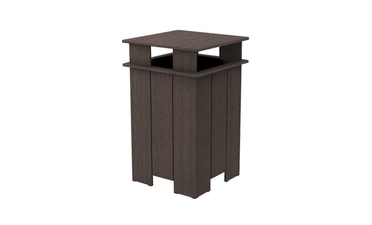 The Mainstay Trash Bin by Ledge Lounger is a tall, dark brown patio can with a square open top. It features vertical slats and a protective overhang, crafted from UV stable materials for durability in outdoor conditions.