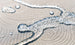 Close-up of clear water droplets on the beige spiral-patterned, waterproof fabric of the Ledge Lounger Laze Pillow, an outdoor comfort accessory. The droplets showcase the texture and water-repellent properties of this floating pool cushion.