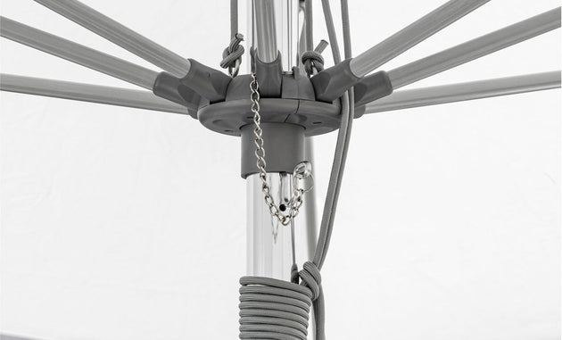 The Essential Fiberglass Umbrella - 8.5 Rectangle Pulley by Ledge Lounger features a corrosion-resistant gray metal mechanism with visible ribs, a pulley system with a chain, and a coiled rope. The durable white fabric complements its robust construction designed to withstand the elements.