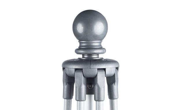Close-up of a grey, spherical object resembling the round top of the Ledge Lounger Essential Fiberglass Umbrella - 8.5 Rectangle Pulley, featuring a cylindrical base secured by metallic prongs. The white backdrop highlights its wind-resistant design.