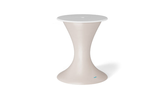 The Autograph Umbrella Stand Ice Bin by Ledge Lounger, with its modern hourglass-shaped beige base and round white top, complements an outdoor setting. Its elegant design features a smooth curve with a small blue logo near the base, set against a plain white background.