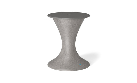 The Ledge Lounger Autograph Umbrella Stand Ice Bin is a sleek, modern, gray hourglass-shaped stand with a smooth wide base and circular top. It features a center hole, making it versatile as both an outdoor table that accommodates an umbrella stand and doubles as an ice bin.