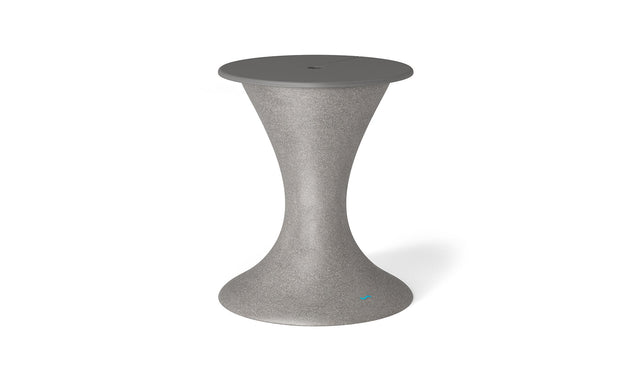 The Ledge Lounger Autograph Umbrella Stand Ice Bin is a sleek, modern, gray hourglass-shaped stand with a smooth wide base and circular top. It features a center hole, making it versatile as both an outdoor table that accommodates an umbrella stand and doubles as an ice bin.