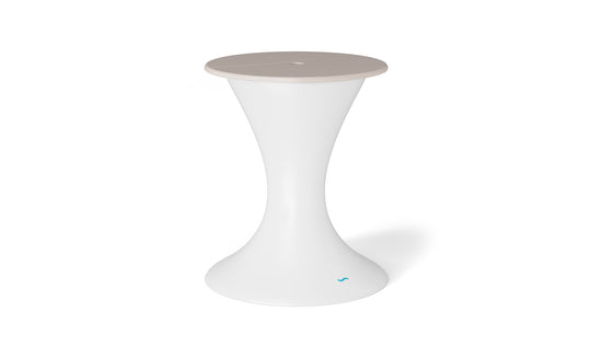 The Autograph Umbrella Stand Ice Bin by Ledge Lounger features a sleek white pedestal with a flared base and a beige circular top, doubling as an elegant outdoor table, set against a plain white backdrop.