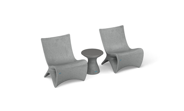 Two Classic Luxury In-Pool Chair Duo by Ledge Lounger and a matching round side table are set in a minimalist style. The chairs have a sleek, curved design, and the side table features a tapered base, all against a white background.