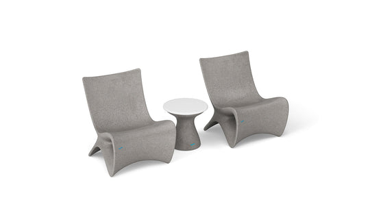 Two Classic Luxury In-Pool Chair Duo by Ledge Lounger, with high backs and curved gray design similar to the Autograph chair, flank a small round white table with a minimalist cylindrical look.