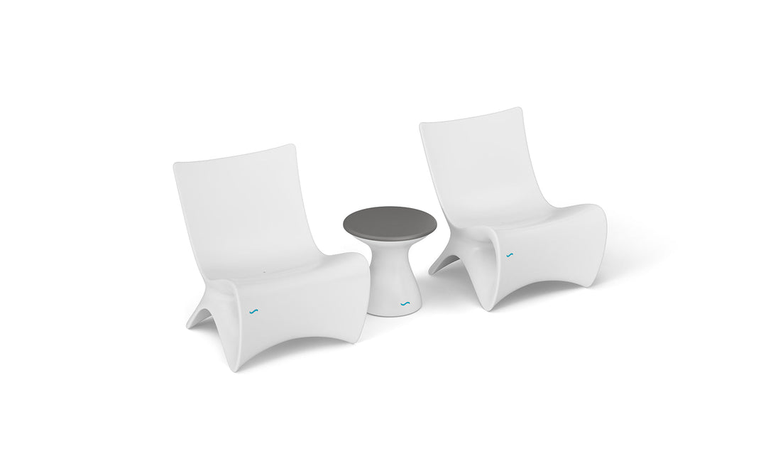 The Classic Luxury In-Pool Chair Duo by Ledge Lounger features two modern, white lounge chairs with curved backs, paired with a small round side table with a dark gray top, elegantly displayed on a plain white background.