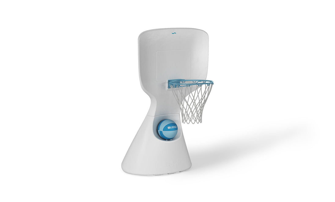 The Hoopstr by Ledge Lounger is a modern, white poolside basketball stand perfect for family fun. It features a compact, minimalist design with a smooth backboard, blue-railed hoop and net, and an easily repositionable base with a blue circular detail.