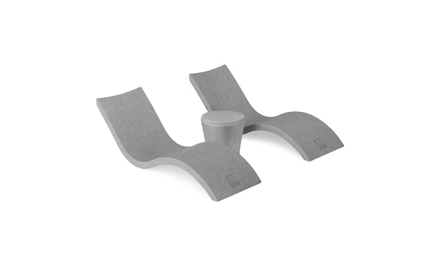 The Ledge Lounger Signature Chaise and Affinity Side Table In-Pool Set features two modern gray wave-shaped loungers with a side table between them, displayed on a white background.