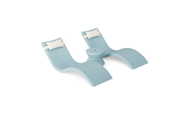 The Ledge Lounger Signature Chaise Headrest Pillow and Side Table In-Pool Set features a light blue double lounger with curved seats, plush white headrest pillows, and a round center table—ideal pool ledge furniture for your outdoor oasis, shown on a plain white background.
