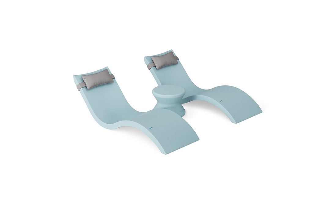 The Ledge Lounger Signature Chaise Headrest Pillow and Side Table In-Pool Set features two modern light blue lounge chairs with headrests and a central round table, ideal pool ledge furniture for your outdoor paradise, shown on a plain white background.