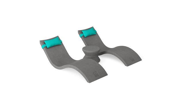 The Ledge Lounger Signature Chaise Headrest Pillow and Side Table In-Pool Set features two modern gray chaises with turquoise pillows and a round table—ideal for lounging poolside or creating an outdoor retreat, shown on a white background.