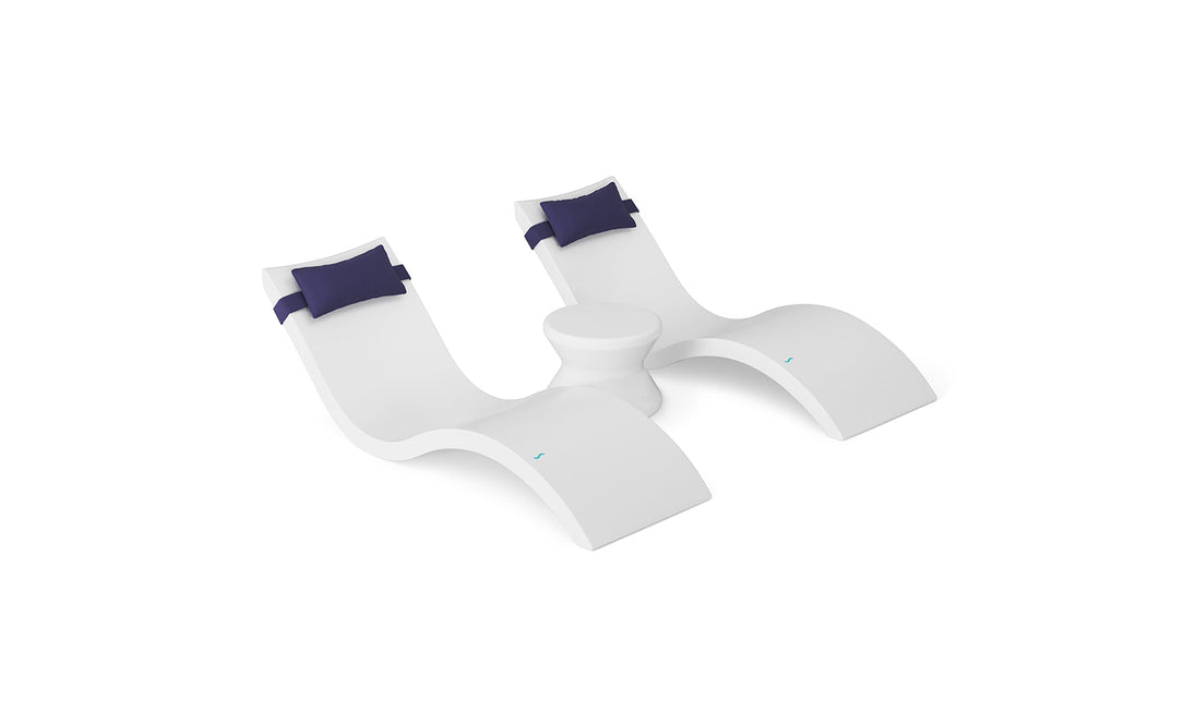 The Ledge Lounger Signature Chaise Headrest Pillow and Side Table In-Pool Set features two modern white chaise loungers with blue headrests connected by a sleek round table, ideal for relaxing and elevating your outdoor space.