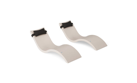 The Ledge Lounger Signature Chaise and Headrest Pillow In-Pool Set features two modern beige chaises with black headrest pillows, side by side on a white background—ideal as stylish outdoor patio furniture.