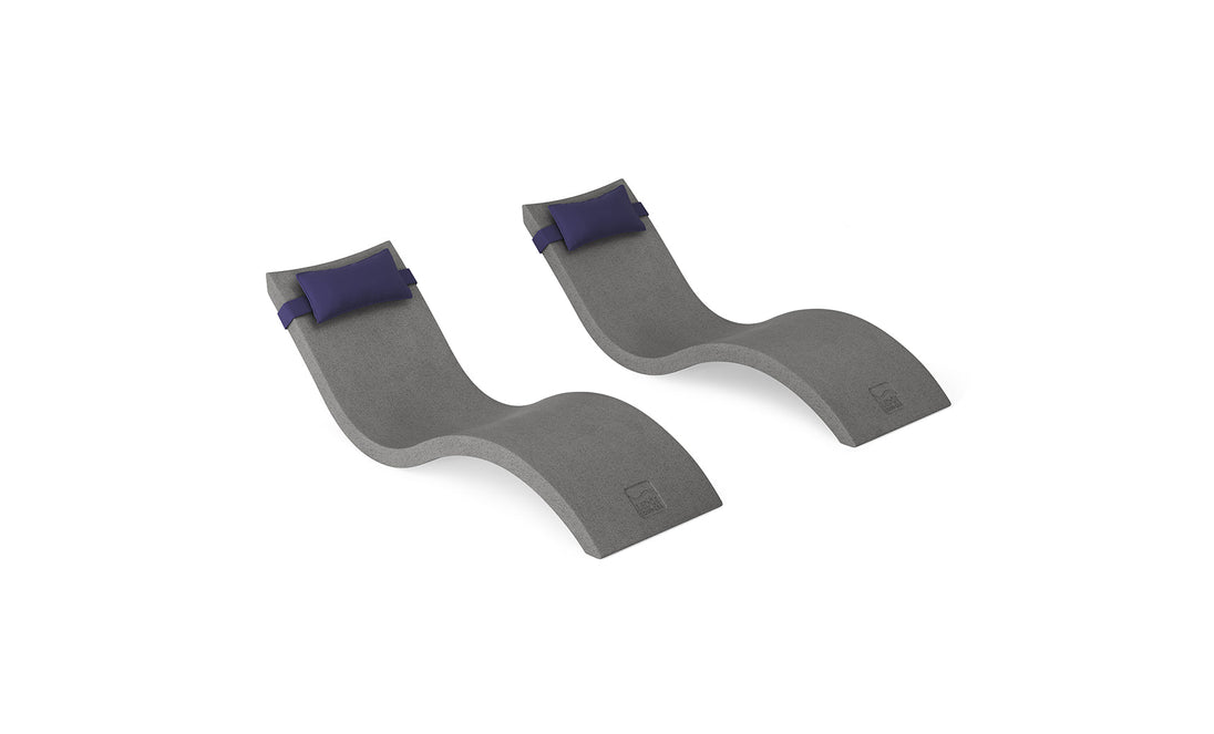 The Ledge Lounger Signature Chaise and Headrest Pillow In-Pool Set features two modern, wave-shaped gray chaises with navy pillows, side by side on white—perfect for creating your own outdoor escape.