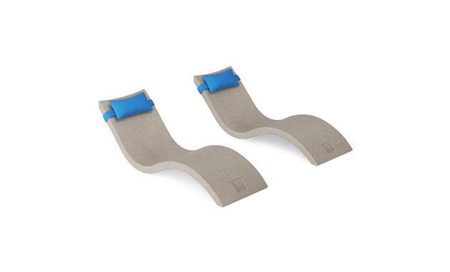 Create your ideal outdoor escape with the Ledge Lounger Signature Chaise and Headrest Pillow In-Pool Set—two modern, wave-shaped beige loungers with blue pillows, shown on a white background.
