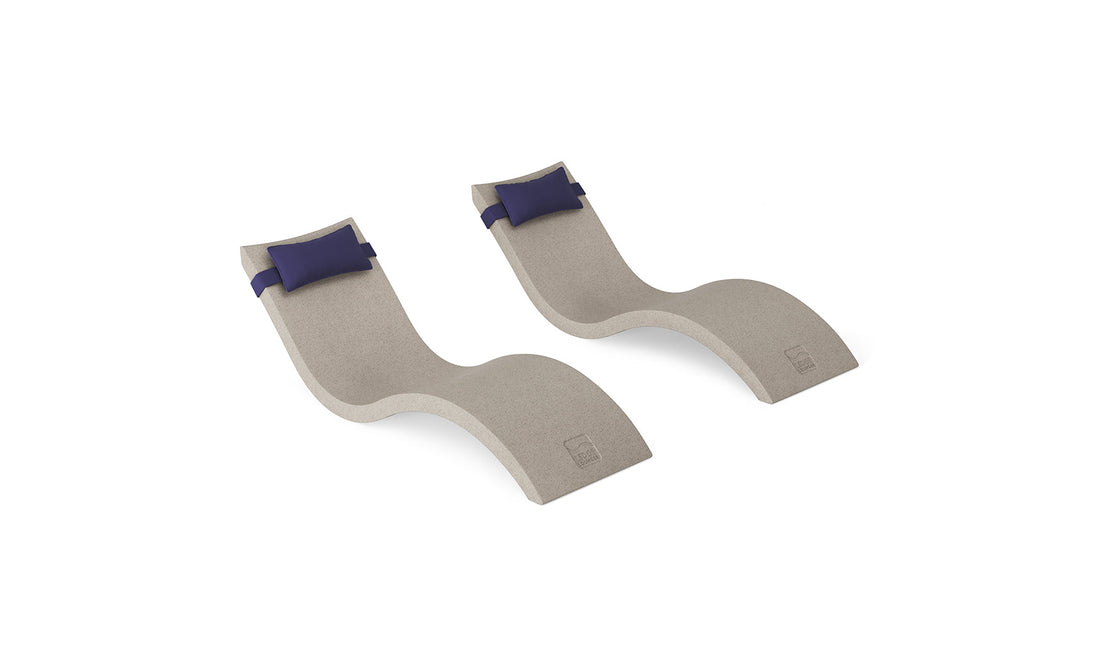 The Ledge Lounger Signature Chaise and Headrest Pillow In-Pool Set features two modern curved loungers with beige surfaces and navy blue headrests—ideal for creating your perfect outdoor retreat.
