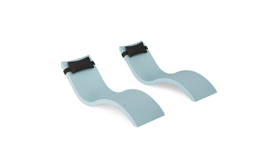 The Signature Chaise and Headrest Pillow In-Pool Set by Ledge Lounger features two modern, light blue wave-shaped loungers with black pillows, creating an ideal outdoor escape, displayed on a white background.