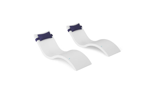 The Ledge Lounger Signature Chaise and Headrest Pillow In-Pool Set features two sleek white lounges with dark blue headrest pillows, placed side by side on a white background for modern outdoor comfort and style.