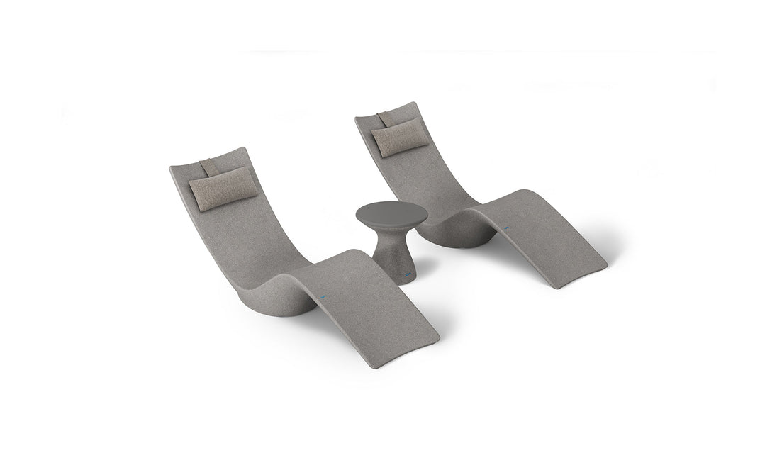 The Ledge Lounger Resort Luxury Outdoor Paradise In-Pool Furniture Bundle includes two modern grey chaise loungers with beige cushions, set around a small round table. Perfect for poolside relaxation, this chic set stands out against a white backdrop, showcasing its sleek design.