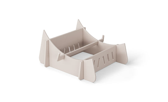 A beige cardboard laptop stand on a white background, the Signature Chaise Riser by Ledge Lounger, features a slotted design and raised support edges for securely holding your device, offering an elevated experience akin to a day by the pool.