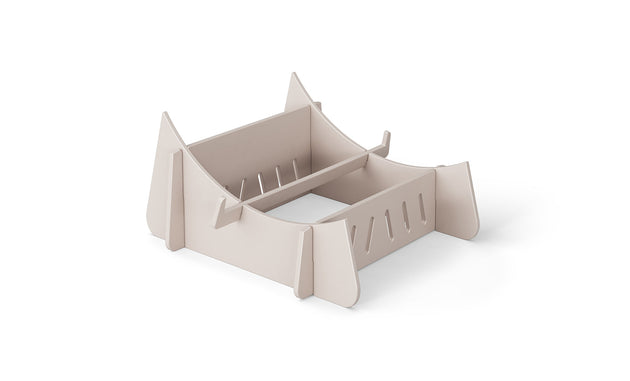 A beige cardboard laptop stand on a white background, the Signature Chaise Riser by Ledge Lounger, features a slotted design and raised support edges for securely holding your device, offering an elevated experience akin to a day by the pool.